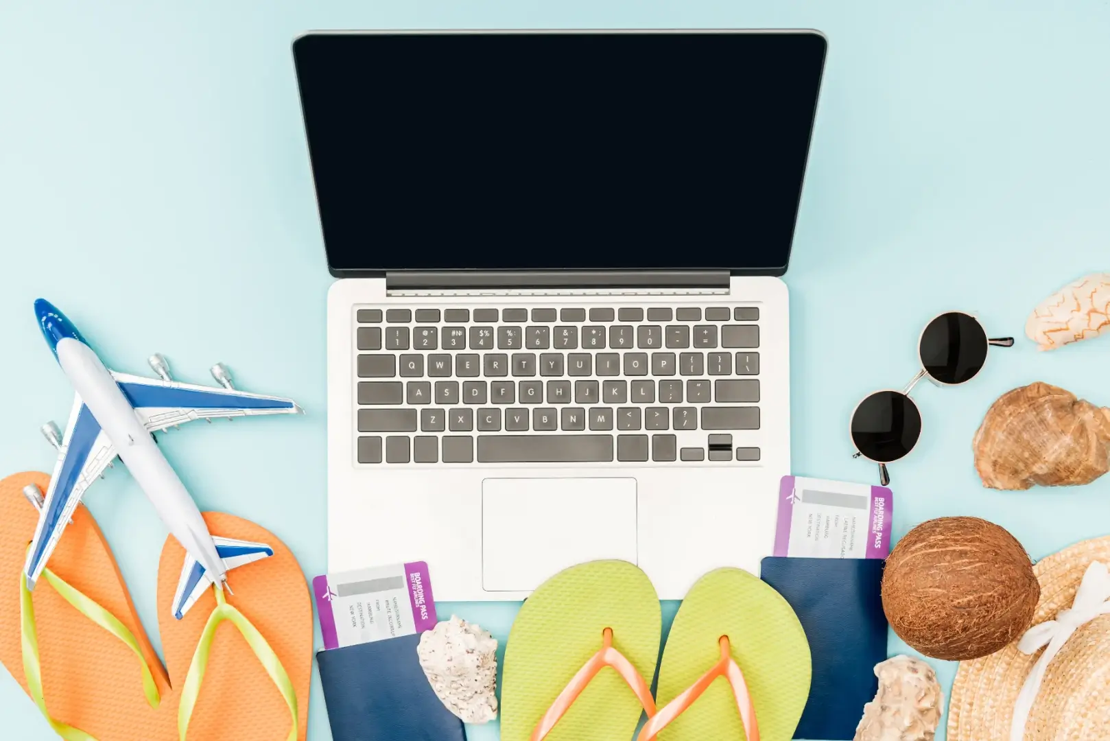 Laptop, model airplane, passport, and travel accessories